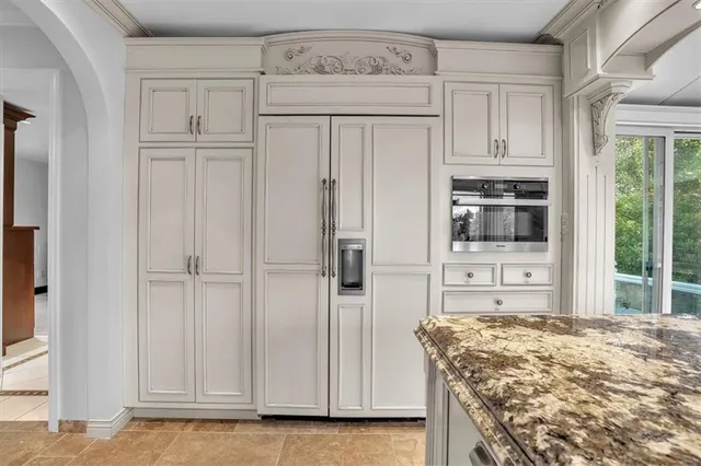 a view of a kitchen with white cabinets and wooden floor