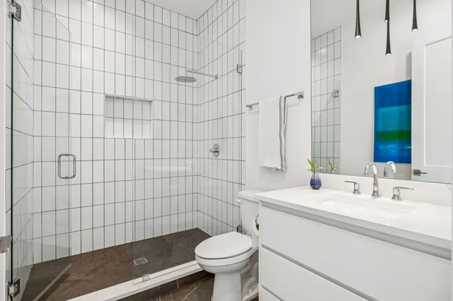 a bathroom with a sink a toilet and shower