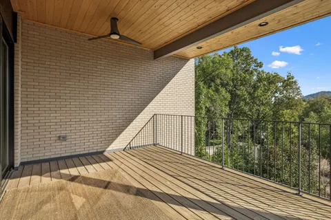 a view of a balcony with wooden floor and fence