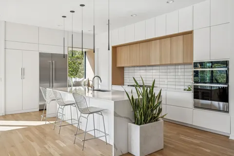 a view of a dining room with furniture a potted plant and wooden floor