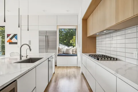 a kitchen with granite countertop a sink stove and cabinets