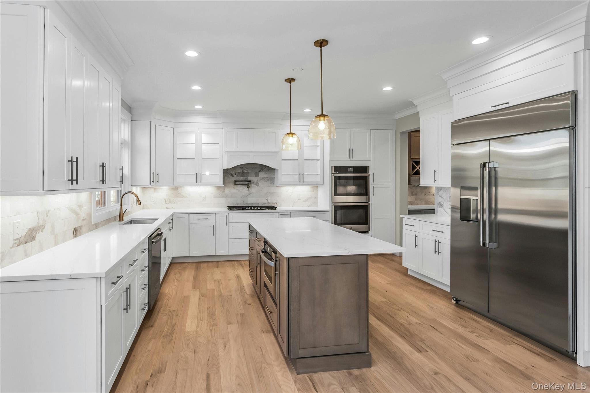 47 Shelter Hill Road Plainview, NY 11803 - Photo 8 of 22 a large kitchen with stainless steel appliances kitchen island granite countertop a large counter top a stove a refrigerator and a sink