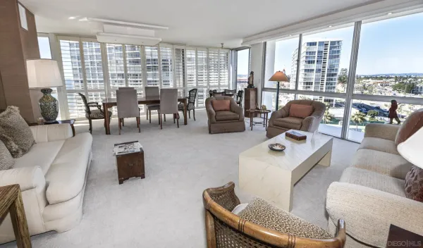 a living room with furniture large windows and flat screen tv