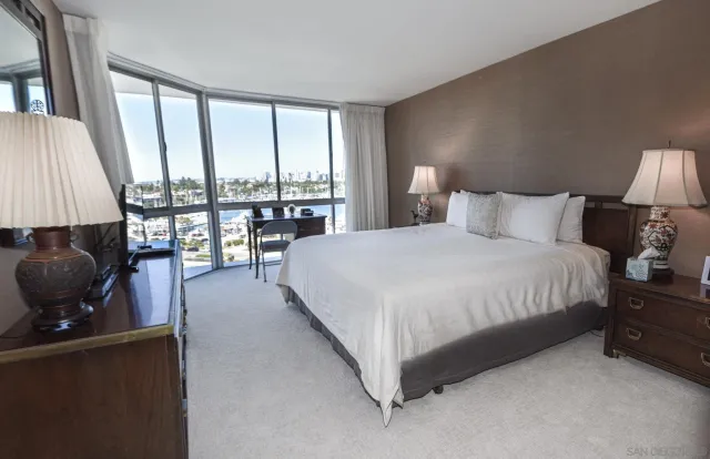 a spacious bedroom with a bed and a large window