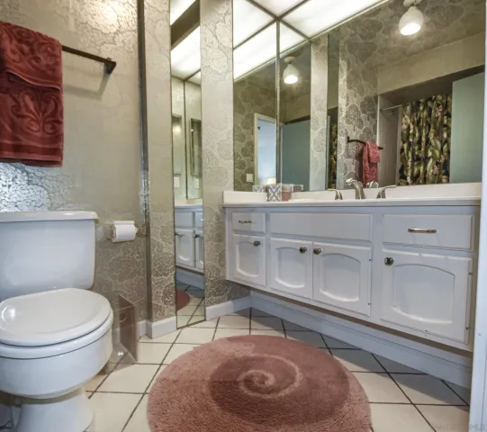 a spacious bathroom with a toilet a sink and mirror