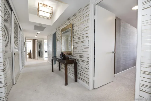 a view of a hallway with a livingroom and furniture