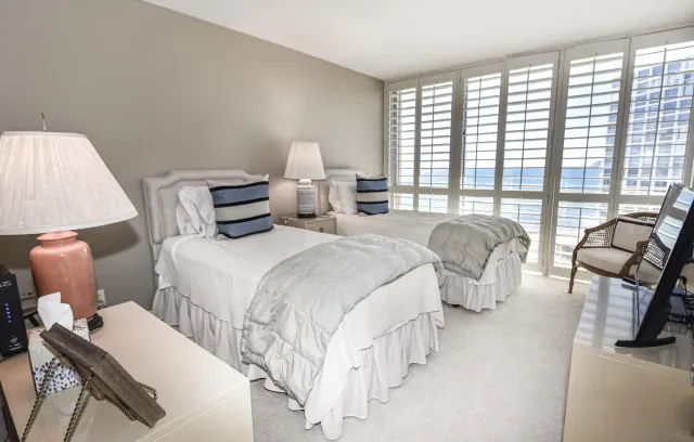 a spacious bedroom with two beds and a large window