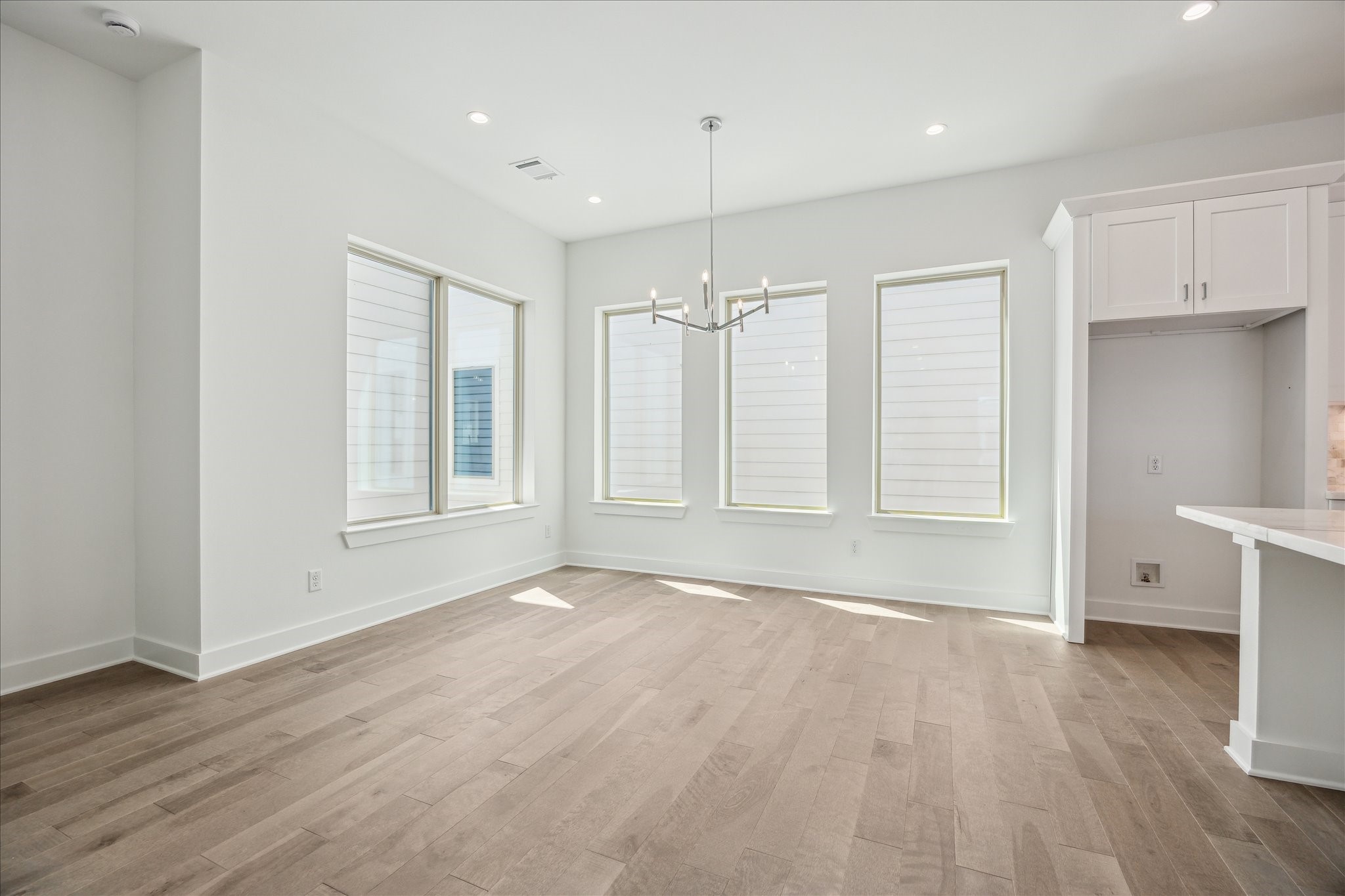 Dining Room that is Surrounded by Windows * Modern Fixtures * Designer Chandelier.