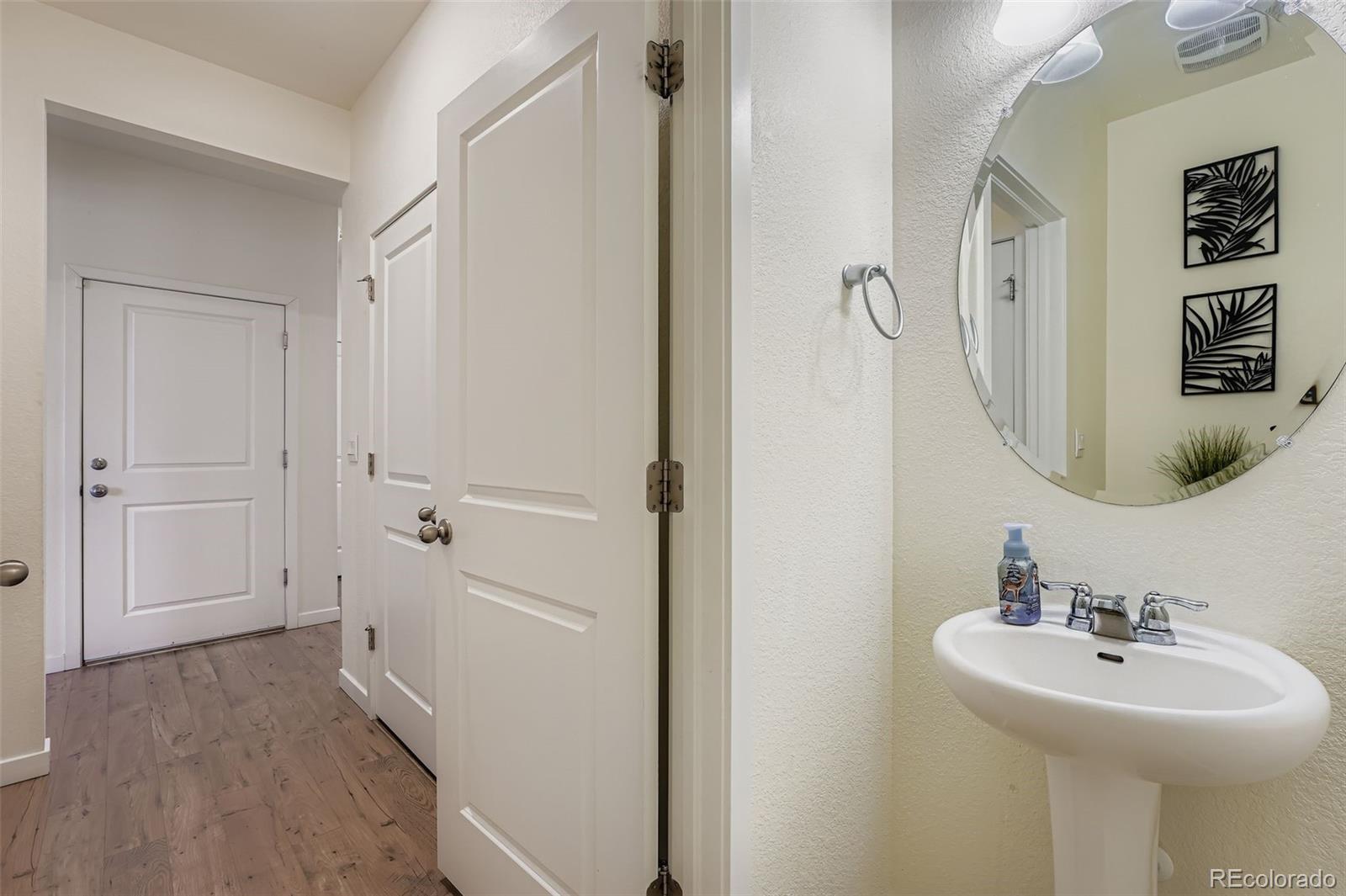 195 Yellowtail Street Bennett, CO 80102 - Photo 12 of 31 a bathroom with a sink a mirror and shower