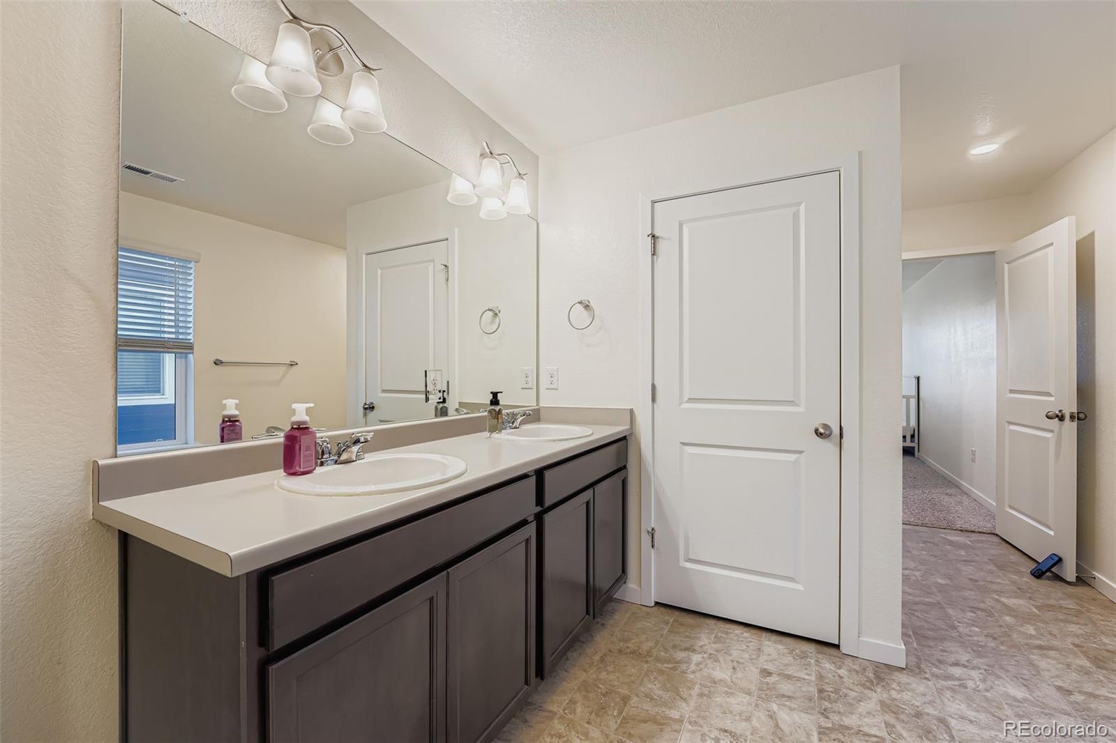 195 Yellowtail Street Bennett, CO 80102 - Photo 17 of 31 a bathroom with a sink and a mirror