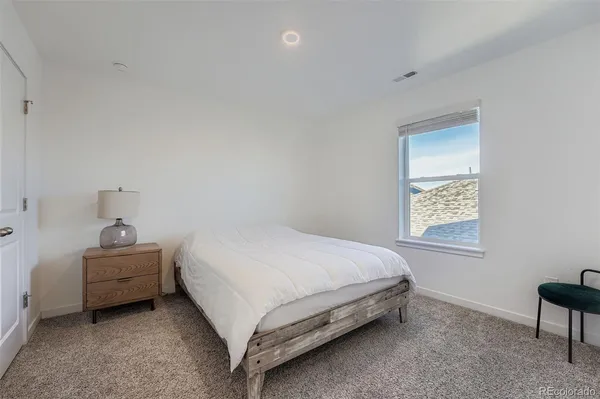 a bed sitting in a bedroom next to a window