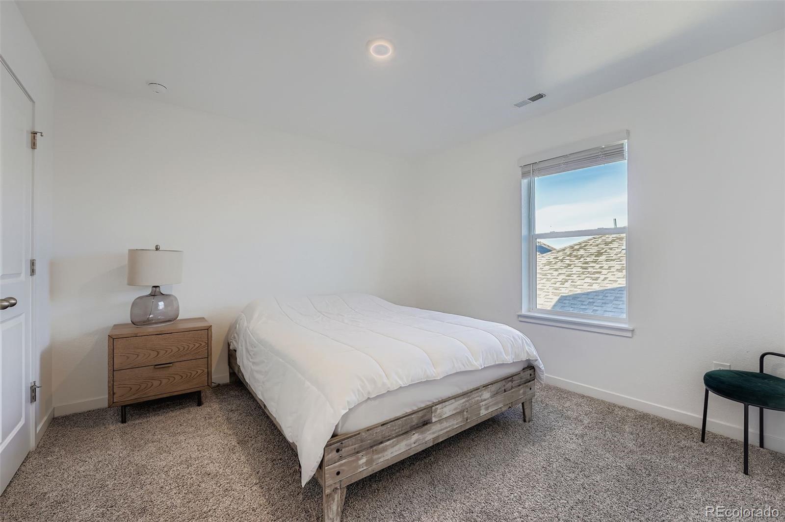195 Yellowtail Street Bennett, CO 80102 - Photo 18 of 31 a bed sitting in a bedroom next to a window