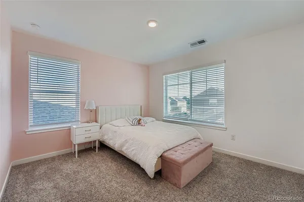 a bedroom with a bed lamp and a window