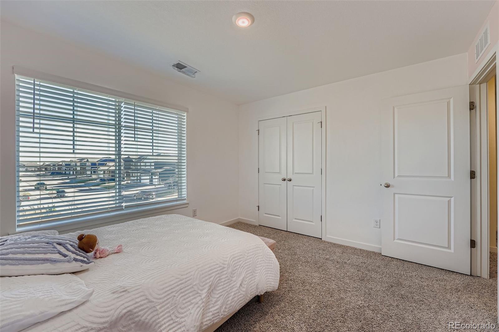 195 Yellowtail Street Bennett, CO 80102 - Photo 21 of 31 a bedroom with a bed and a window