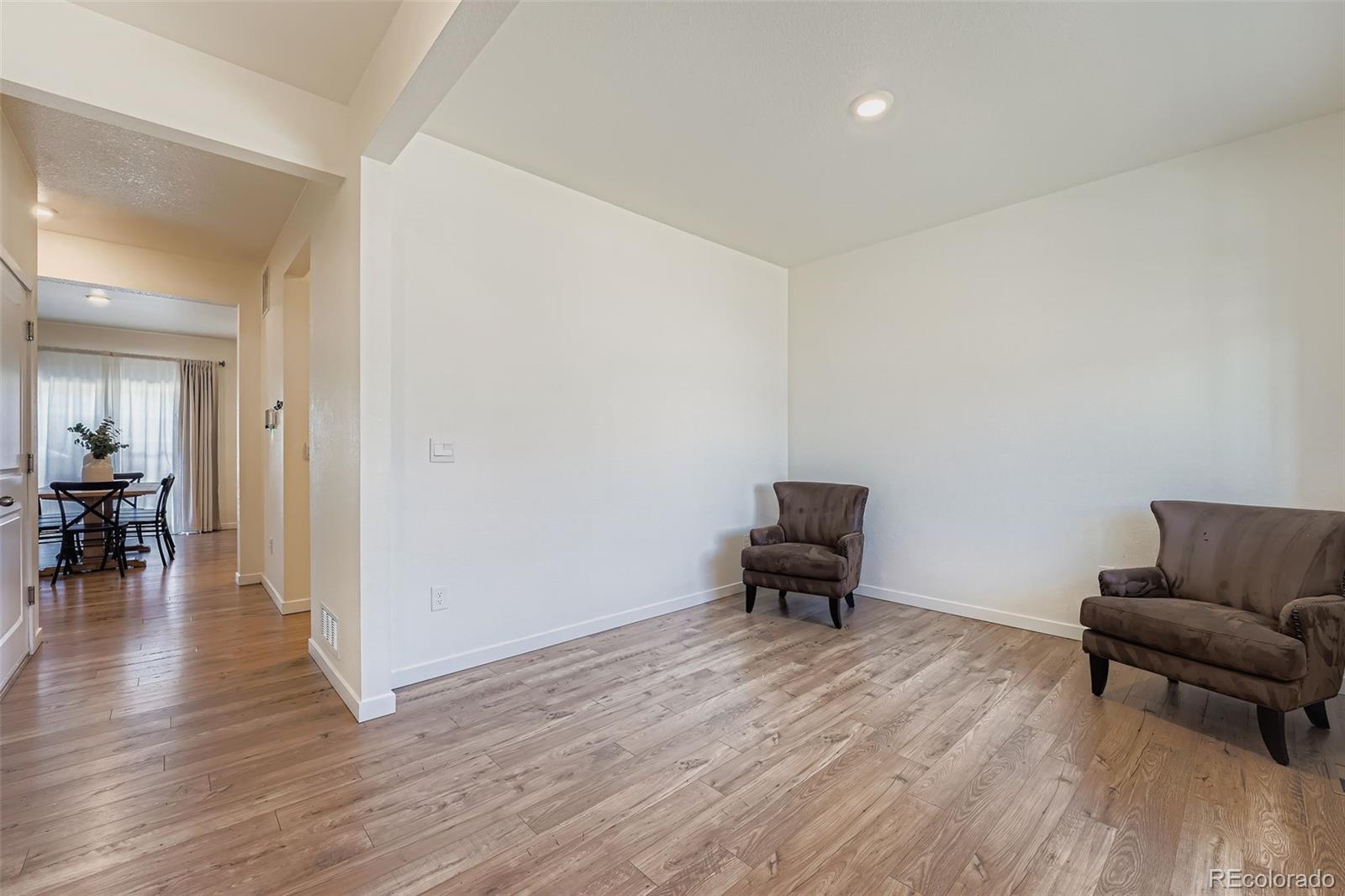 195 Yellowtail Street Bennett, CO 80102 - Photo 26 of 31 a living room with furniture and a wooden floor