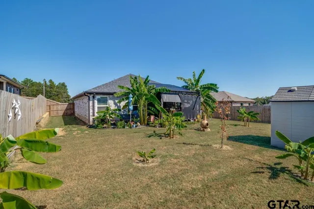 a view of a house with a yard and potted plants