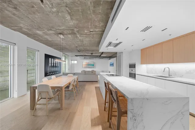 a kitchen with stainless steel appliances a table and chairs