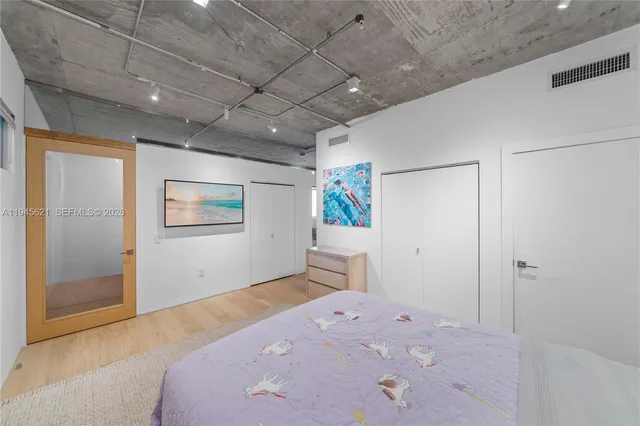 a bedroom with a bed and a painting on the wall