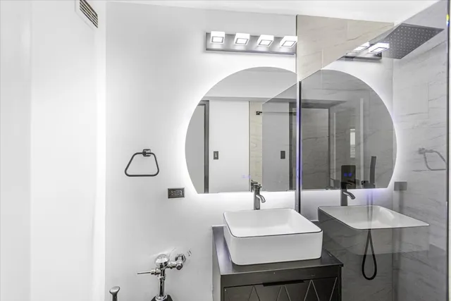 a bathroom with a sink a mirror and a lamp