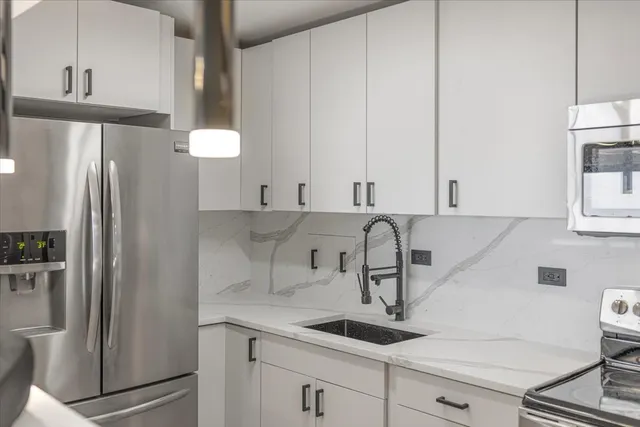 a kitchen with a refrigerator sink and cabinets