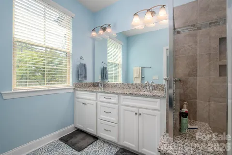 a bathroom with a granite countertop sink a toilet and shower