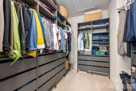 a view of walk in closet with clothes and shoes