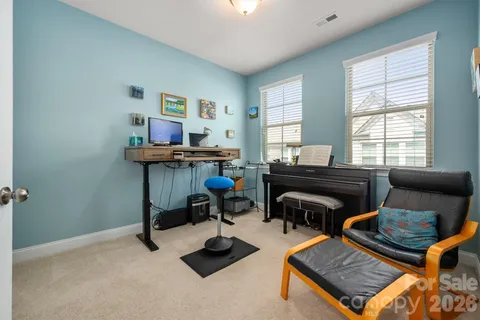 a living room with furniture a piano and a window
