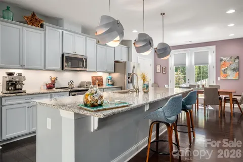 a kitchen with stainless steel appliances granite countertop a stove a sink a kitchen island with a dining table and chairs