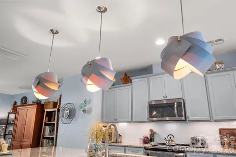 a kitchen with stainless steel appliances granite countertop a sink a microwave oven a stove and a wooden floors