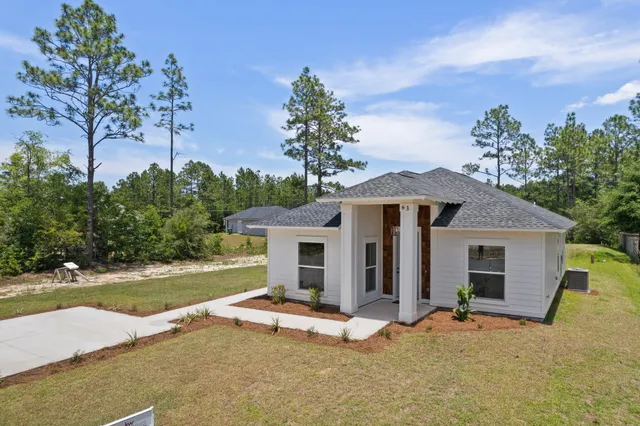 a view of a house with backyard and a tree