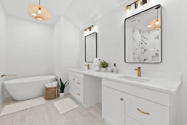 a bathroom with a double vanity sink mirror and bathtub