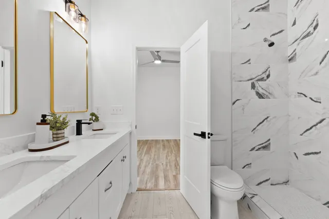 a bathroom with a double vanity sink toilet and shower