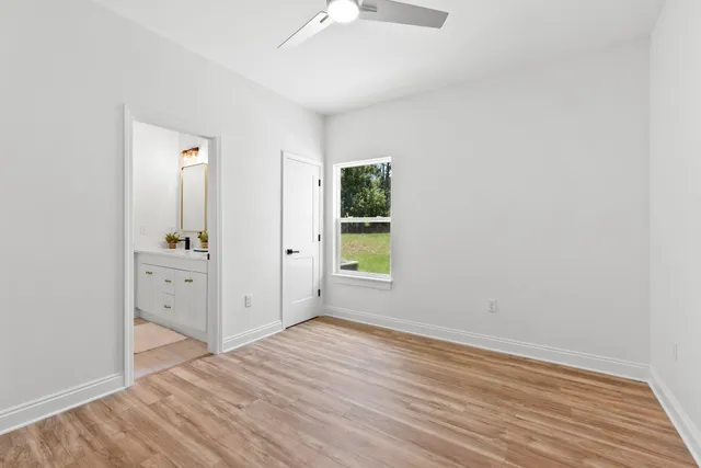 an empty room with window and wooden floor