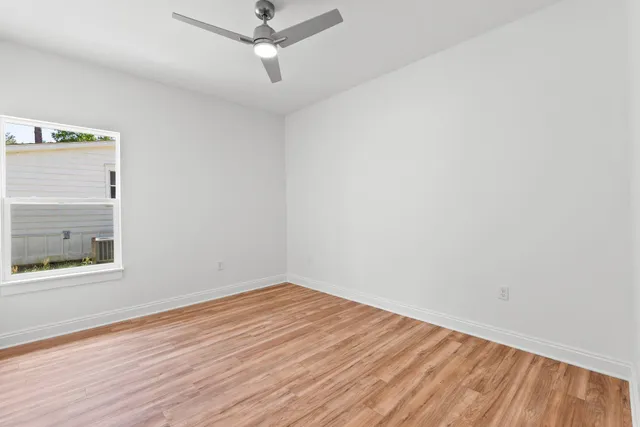 an empty room with a window and wooden floor