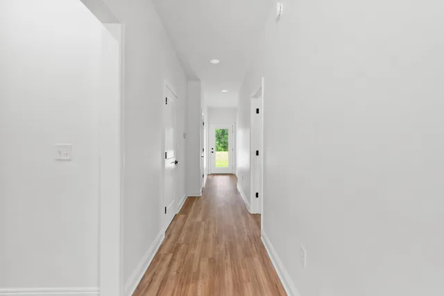 a view of a hallway with wooden floor