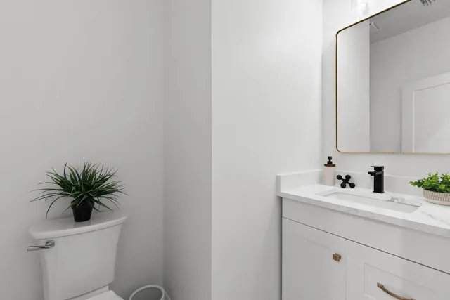 a bathroom with a sink a toilet and a mirror