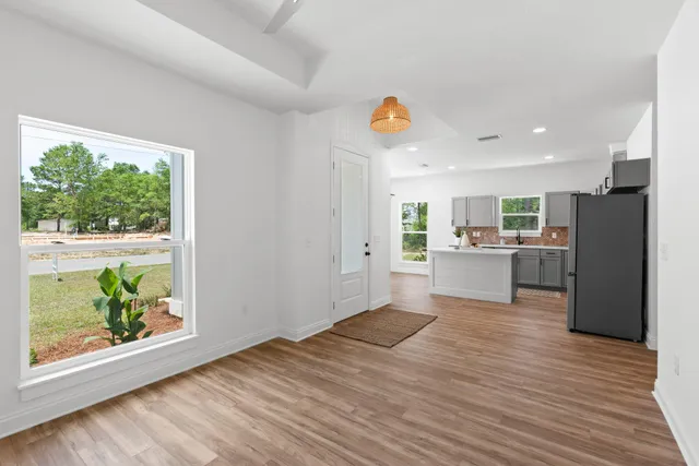 a view of a kitchen with wooden floor and windows