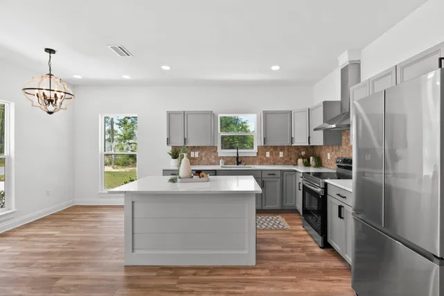 a kitchen with stainless steel appliances granite countertop a sink stove and refrigerator
