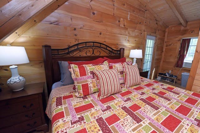 360 Johnson Cove Road Copperhill, TN 37317 - Photo 12 of 56 a bedroom with a bed and a lamp on dresser