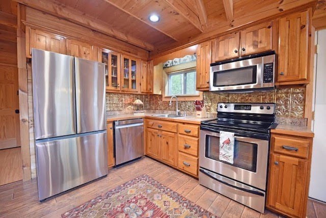 360 Johnson Cove Road Copperhill, TN 37317 - Photo 2 of 56 a kitchen with stainless steel appliances granite countertop a stove a sink and a refrigerator