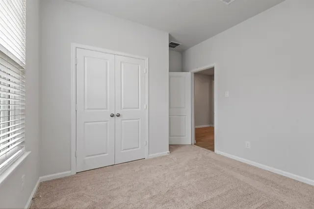 an empty room with windows and closet