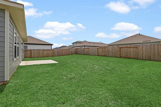 a view of a backyard with a garden and wooden fence
