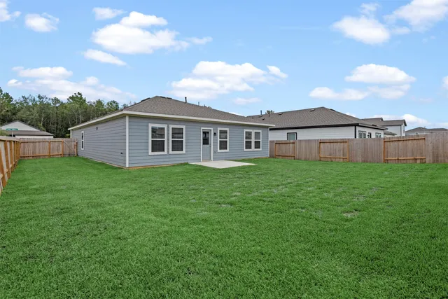a view of a house with a big yard and large trees