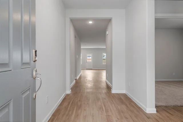 a view of a hallway with wooden floor