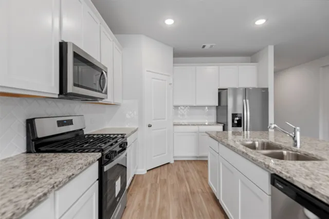 a kitchen with stainless steel appliances granite countertop a sink stove microwave and cabinets