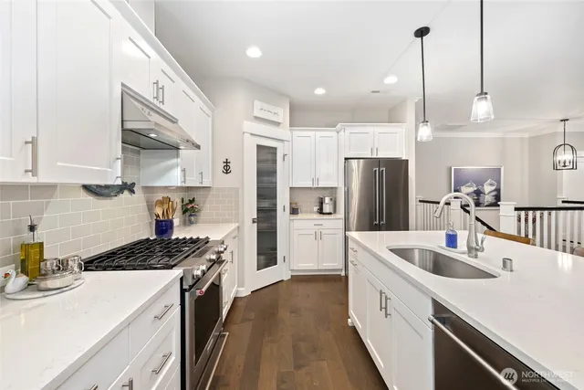 a kitchen with stainless steel appliances a sink stove and refrigerator