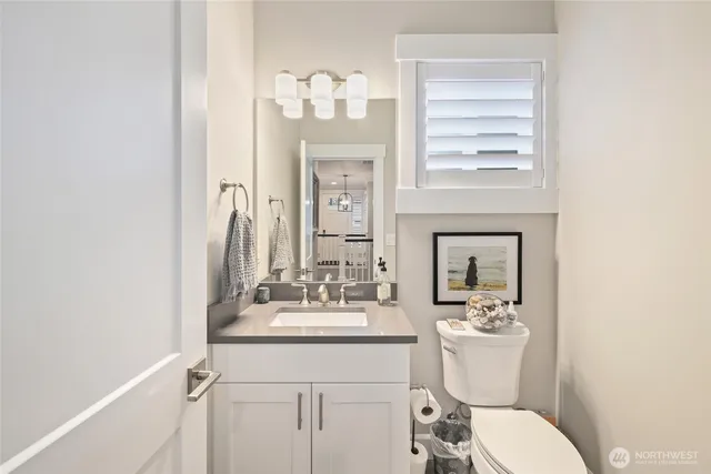 a bathroom with a toilet a sink and mirror