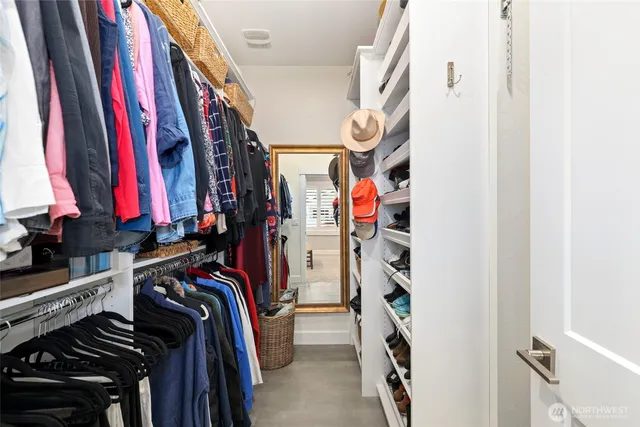 a view of walk in closet with clothes and shoes