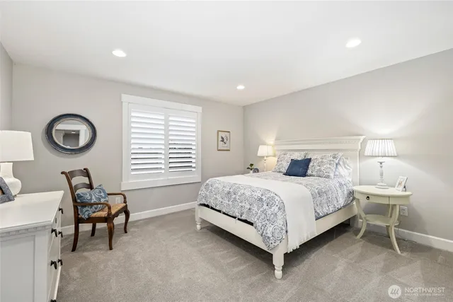 a bedroom with a bed chair and a lamp