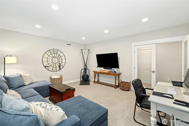 a living room with furniture a flat screen tv and a window